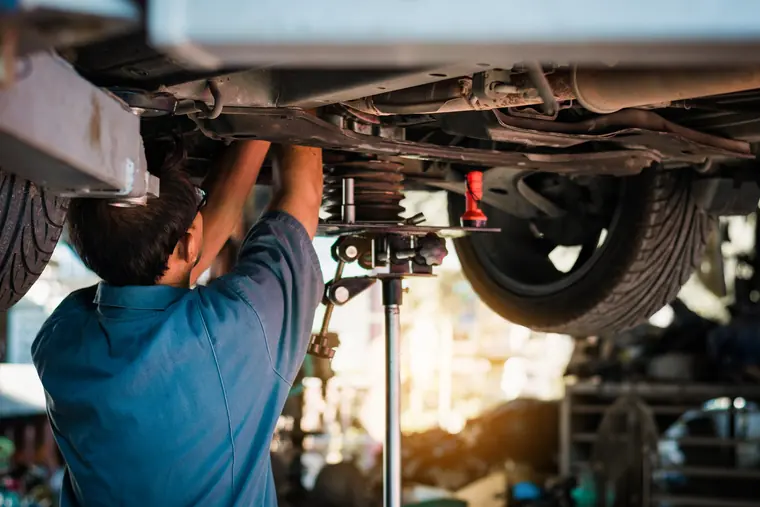 Mechanic working under a car on the lift