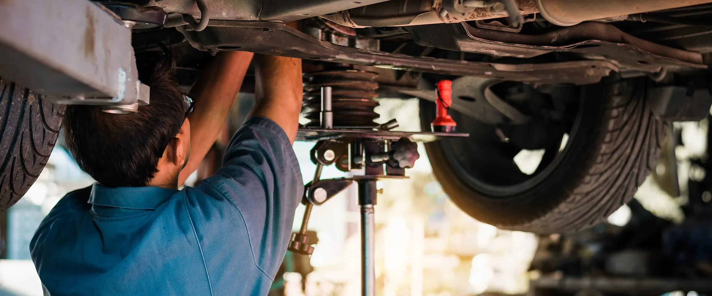 Mechanic working under a car on a lift