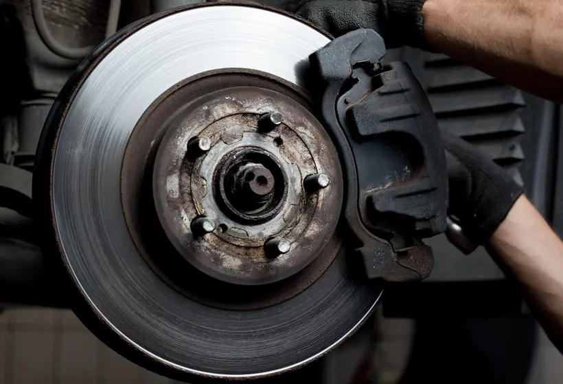 Mechanic fitting a new brake disc and caliper